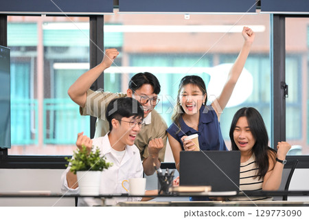 Excited business team celebrating victory or successful project results together in an office Excited business team celebrating victory or successful project results together in an office 129773090