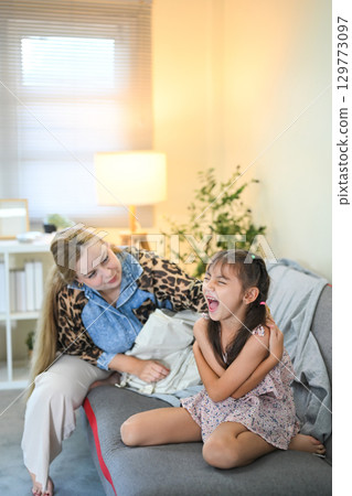 Child cries and resists while mother attempts to prepare her for school 129773097