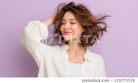 Smiling caucasian young woman posing against purple background. 129773539
