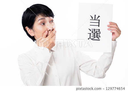 一位驚訝的老年婦女拿著一張寫著「獲勝者」的紙 129774654