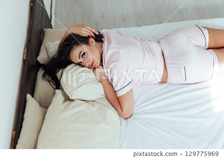 Good morning, new day, weekend, holiday. Happy Young Woman sets on Bed, teen Girl Stretching arms after sleep and enjoying morning Good morning, new day, weekend, holiday. Happy Young Woman sets on Bed, teen Girl Stretching arms after sleep and enjoying morning 129775969