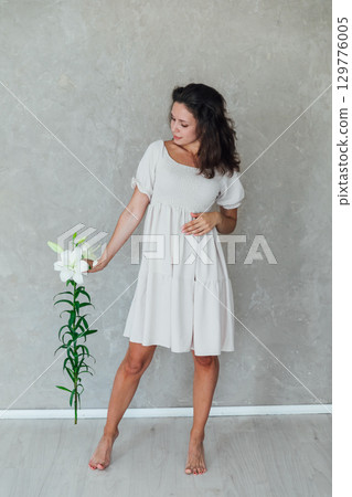 woman with funeral lily flowers on white background woman with funeral lily flowers on white background 129776005