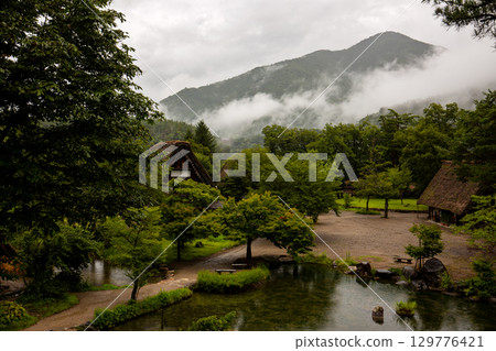 Shirakawa-go pond and old Gassho-style houses in the summer rain Shirakawa-go pond and old Gassho-style houses in the summer rain 129776421