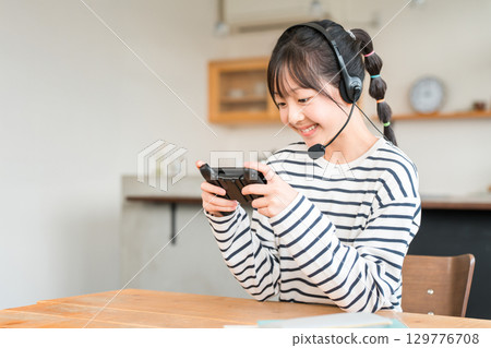 Online games in the living room, elementary school, junior high school, and high school girls playing video games Online games in the living room, elementary school, junior high school, and high school girls playing video games 129776708