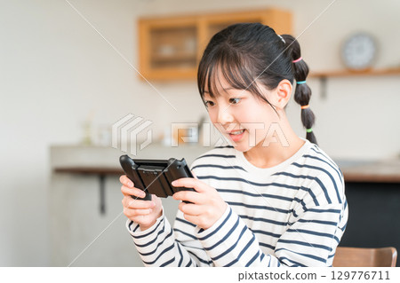 Online games in the living room, elementary school, junior high school, and high school girls playing video games 129776711