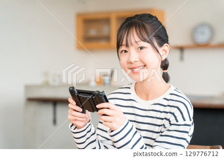 Online games in the living room, elementary school, junior high school, and high school girls playing video games 129776712