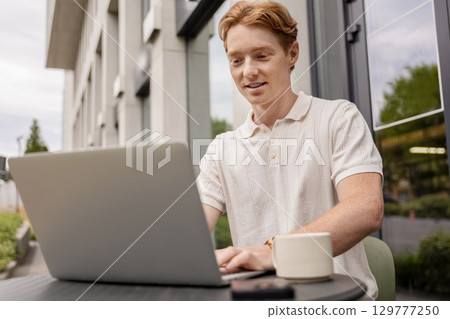 Remote worker focused on screen typing fast outdoors surrounded 129777250