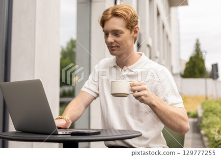 Self-employed businessman holding cup and browsing freelance platform Self-employed businessman holding cup and browsing freelance platform 129777255