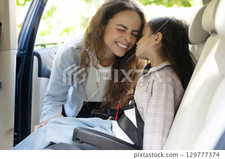 Mom and daughter in a car feeling happy and pleased 129777374