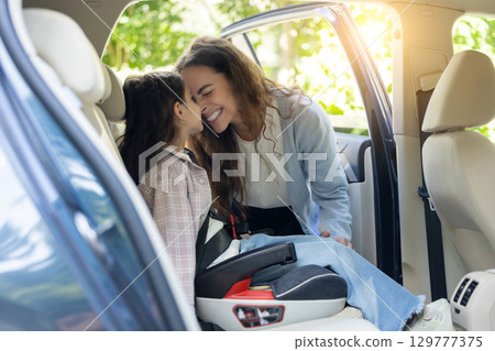 Mom and daughter in a car feeling happy and pleased 129777375