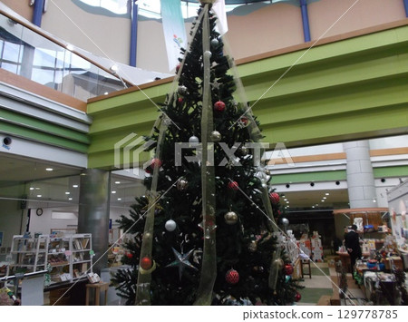 A huge Christmas tree decorated in a shopping mall 129778785