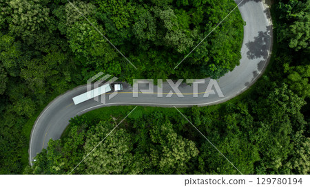 Aerial view semi truck trailer cargo on mountain curve road, Semi truck trailer cargo business logistic transportation on green forest road curve, White semi truck trailer cargo delivery on asphalt 129780194