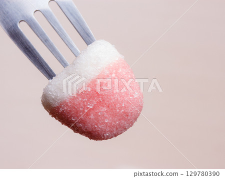 Pink jelly or marshmallow on fork closeup 129780390