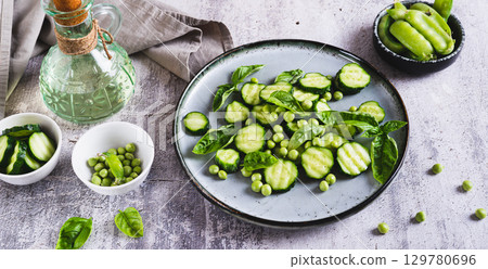 Antioxidant salad of fresh cucumbers, green peas and basil on a plate on the table web banner 129780696