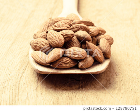 Almonds on wooden spoon Almonds on wooden spoon 129780751