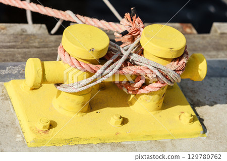 Mooring bollard with rope on pier by the sea 129780762