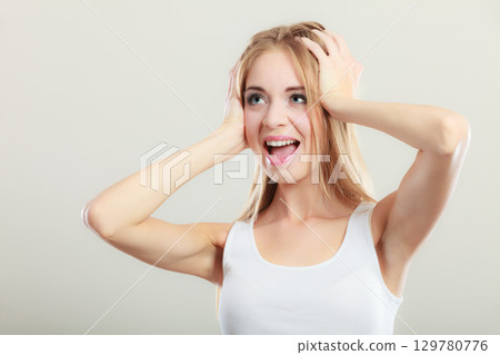 Closeup stressed woman covers ears with hands 129780776