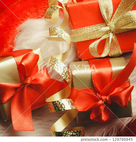 Small red and golden boxes with gifts tied bows Small red and golden boxes with gifts tied bows 129780845