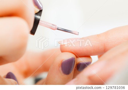 Woman in beauty salon getting manicure done. Woman in beauty salon getting manicure done. 129781036
