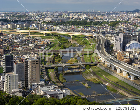 朝陽照射下的河畔街道和穿過橋樑的火車 129781325