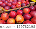 Box of fresh ripe nectarines displayed at a market 129782198