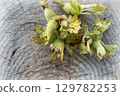 Unripe Hazelnuts in Husks on Rustic Wood 129782253