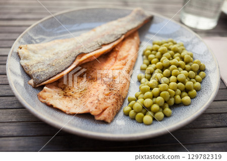 Delicious baked trout fillets with green peas Delicious baked trout fillets with green peas 129782319