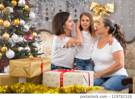 Grandmother mom and daughter on sofa in Christmas interior 129782326