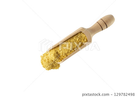 Savoury vegan yeast flakes in wooden scoop isolated on white background. 129782498