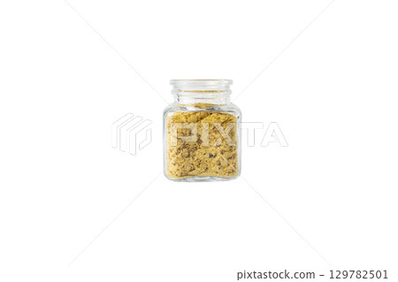 Savoury vegan yeast flakes in a glass jar isolated on white background. Savoury vegan yeast flakes in a glass jar isolated on white background. 129782501