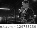 晚上，一名西裝革履的男子在月台上戴著耳機講話 129783130