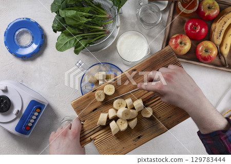 Young man making a healthy smoothie Young man making a healthy smoothie 129783444