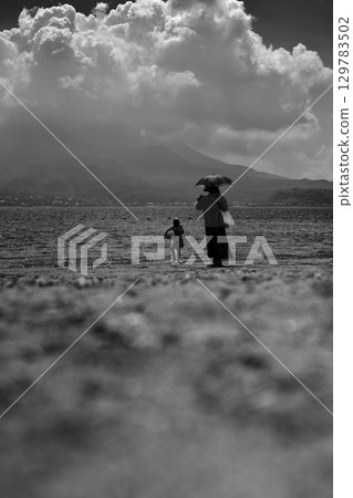Parent and child looking at the sea Parent and child looking at the sea 129783502