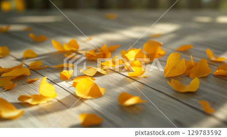 Bright yellow autumn leaves scattered on a wooden surface with natural light . Bright yellow autumn leaves scattered on a wooden surface with natural light . 129783592
