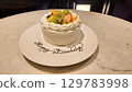 Fruit decorated birthday cake and celebration scene 129783998