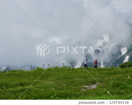 Summer tourist attraction, scenery of the summit of Mt. Murodo on the Tateyama Kurobe Alpine Route, and people sightseeing Summer tourist attraction, scenery of the summit of Mt. Murodo on the Tateyama Kurobe Alpine Route, and people sightseeing 129784116
