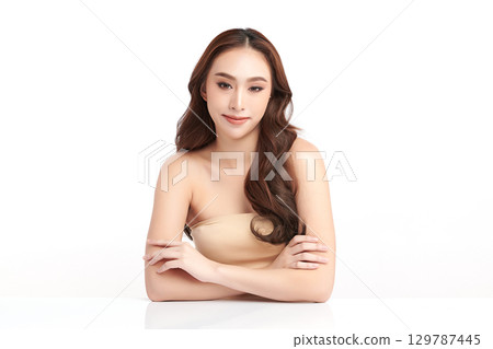 A beautiful young Asian woman with clean, fresh skin against a white background. Skincare, facial treatment, cosmetology, beauty, and spa. An elegant portrait of an Asian woman. 129787445
