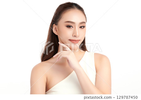 A beautiful young Asian woman with clean, fresh skin against a white background. Skincare, facial treatment, cosmetology, beauty, and spa. An elegant portrait of an Asian woman. A beautiful young Asian woman with clean, fresh skin against a white background. Skincare, facial treatment, cosmetology, beauty, and spa. An elegant portrait of an Asian woman. 129787450