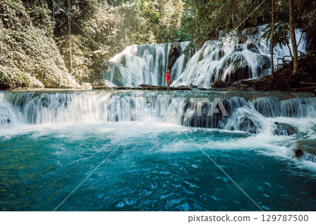 Woman staying on scenic cascade waterfall in Central Sulawesi 129787500