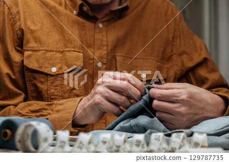 mastering art tailoring jeans in small business setting. closeup. mastering art tailoring jeans in small business setting. closeup. 129787735