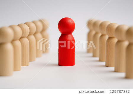 A red pawn between two rows of wooden pawns symbolizing balance, guidance, and leadership influence in structured teams A red pawn between two rows of wooden pawns symbolizing balance, guidance, and leadership influence in structured teams 129787882