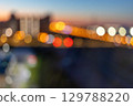 Vibrant city lights blur form beautiful bokeh against dusky skyline, capturing essence of urban life 129788220