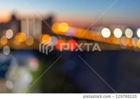 Vibrant city lights blur form beautiful bokeh against dusky skyline, capturing essence of urban life Vibrant city lights blur form beautiful bokeh against dusky skyline, capturing essence of urban life 129788220