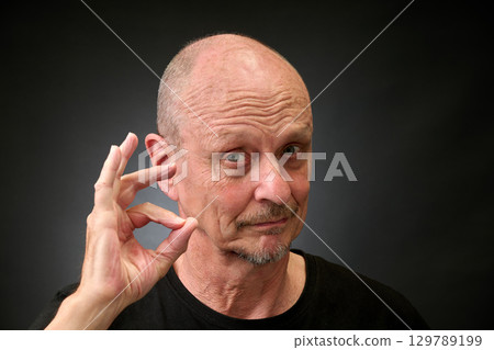 Closeup portrait of a elderly man in studio doying the sign for perfect 129789199