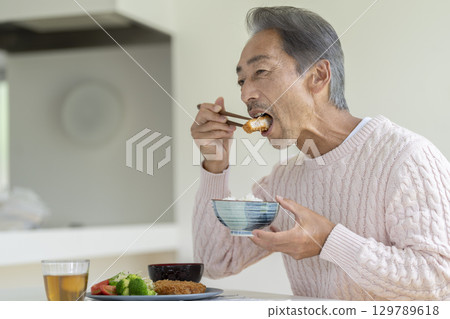 A man in his 60s eating 129789618