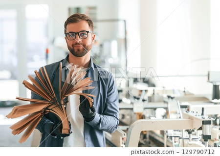 Handsome man is working at the factory of creating eco boxes 129790712