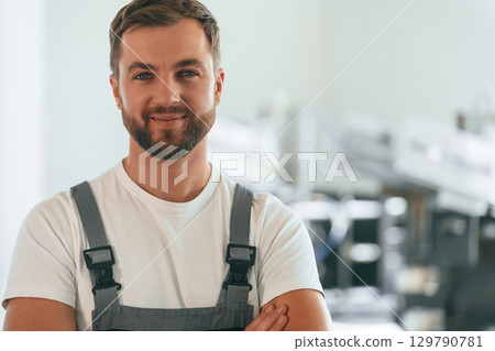 Close up portrait. Handsome man is working at the factory of creating eco boxes 129790781