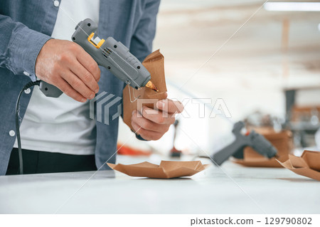 Technician is working. Handsome man is at the factory of creating eco boxes 129790802