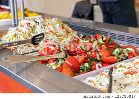 A variety of fresh, colorful salads on a buffet counter at a street food market. A variety of fresh, colorful salads on a buffet counter at a street food market. 129790817