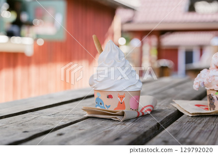 Summer cafe scene with soft serve ice cream and vanilla ice cream served in cute animal patterned cups Summer cafe scene with soft serve ice cream and vanilla ice cream served in cute animal patterned cups 129792020